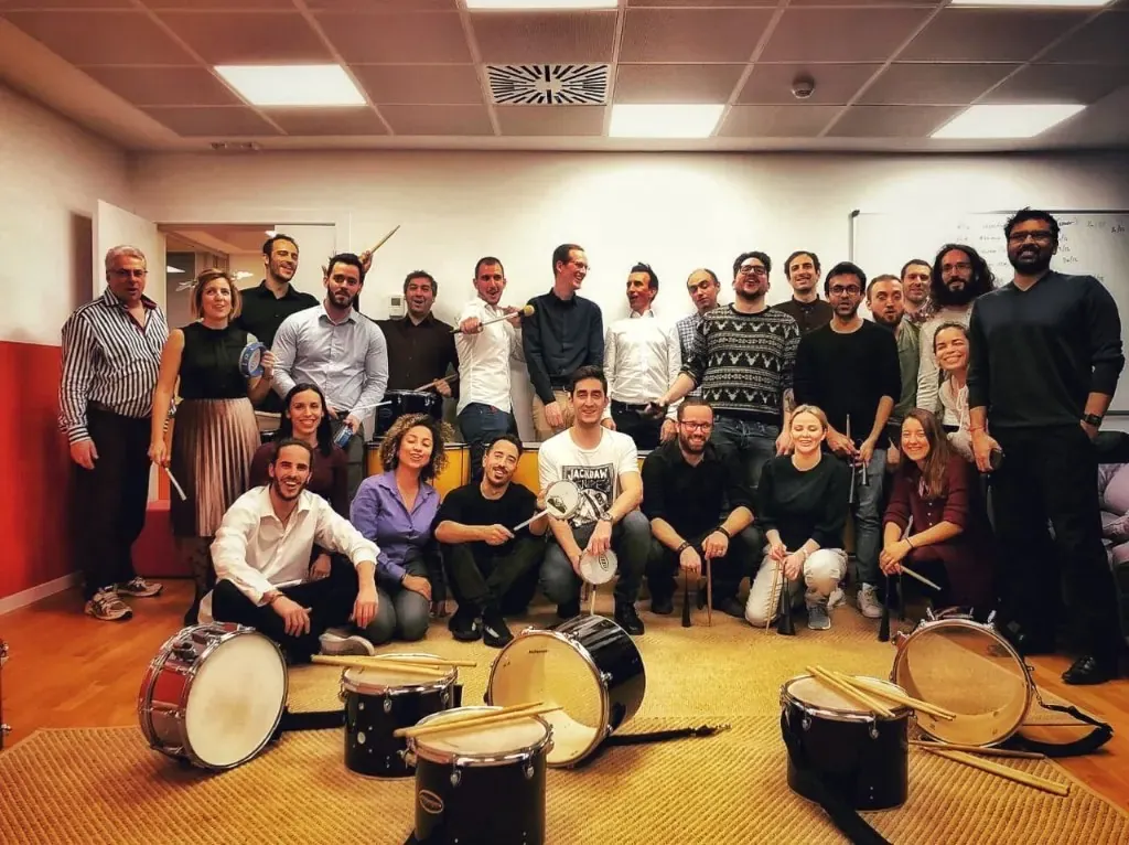 Equip d'empresa posant amb els tambors després d'una experiència TOCART