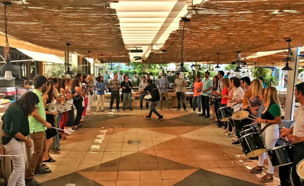 Equip d'empresa posant amb els tambors després d'una experiència TOCART